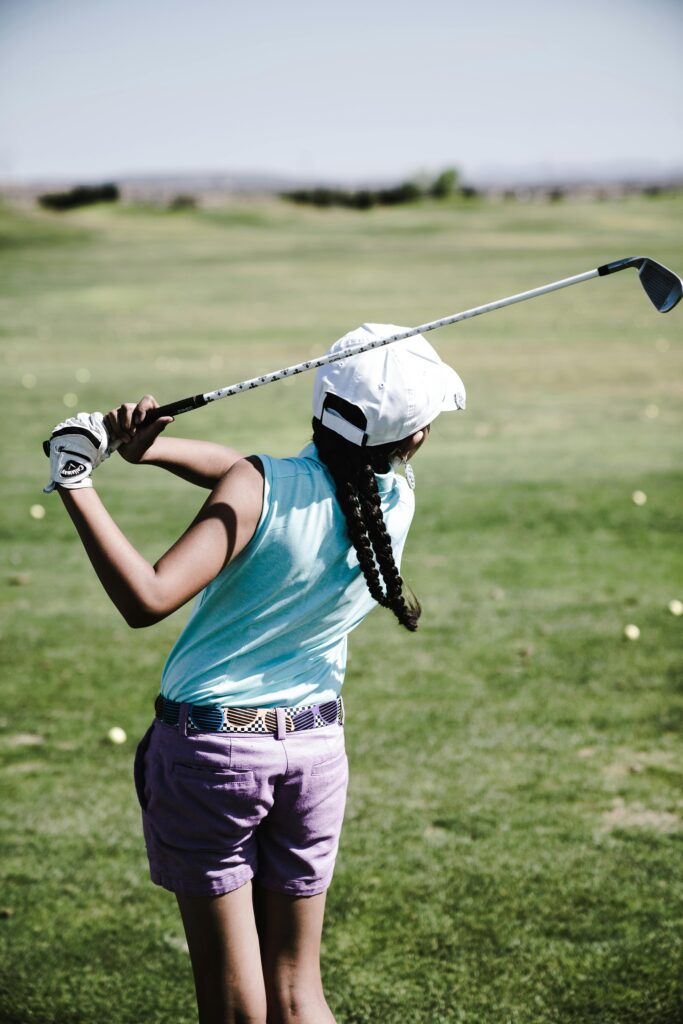 Golfer performing a powerful swing on the course, highlighting the importance of core strength and mobility for improving golf performance.