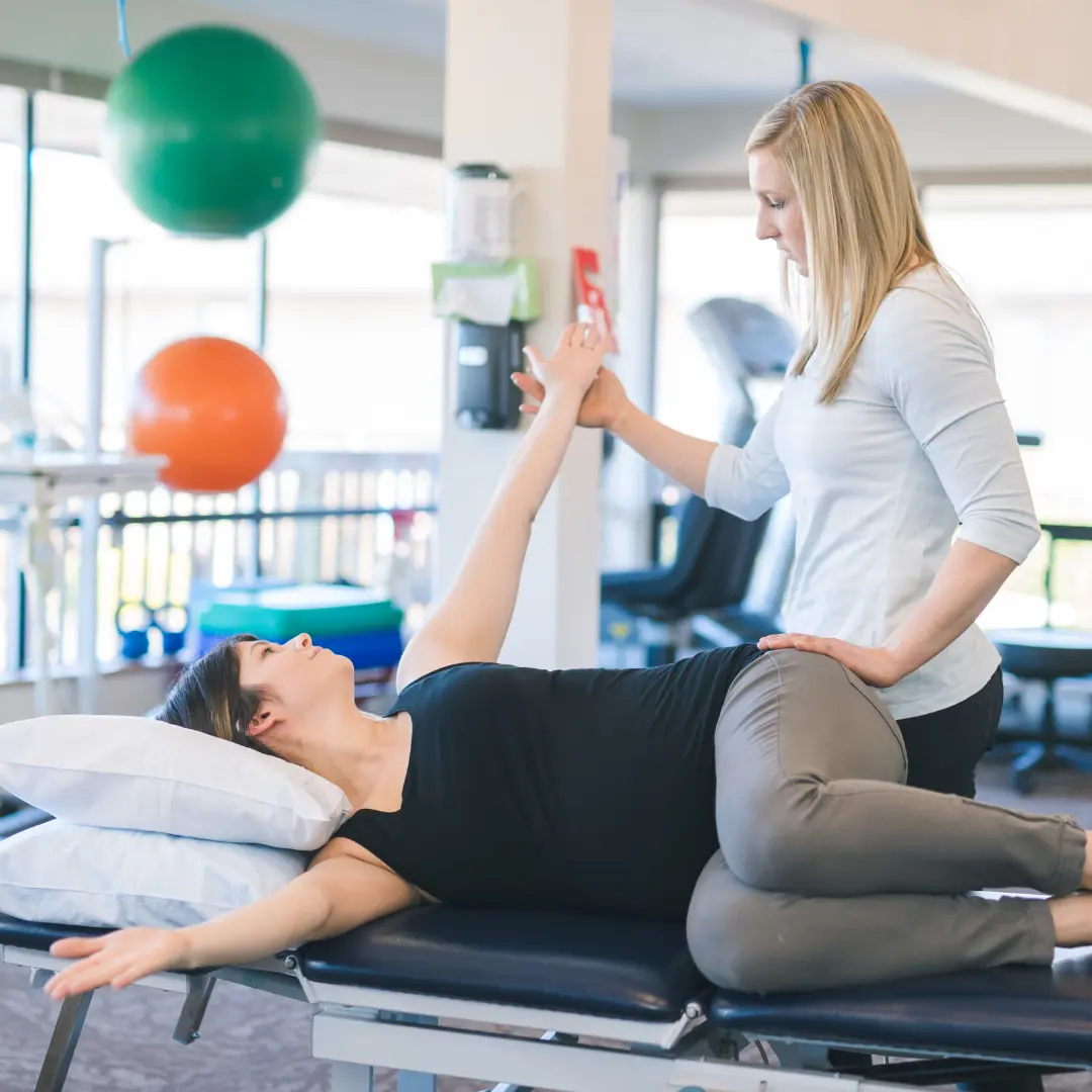 Physical Therapy helping female patient stretch arm